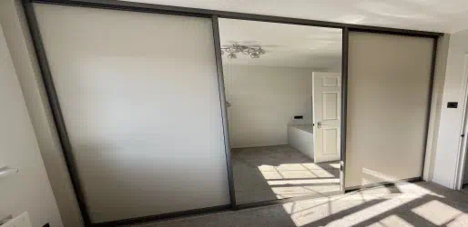 Plain mirror and panel sliding wardrobe doors.