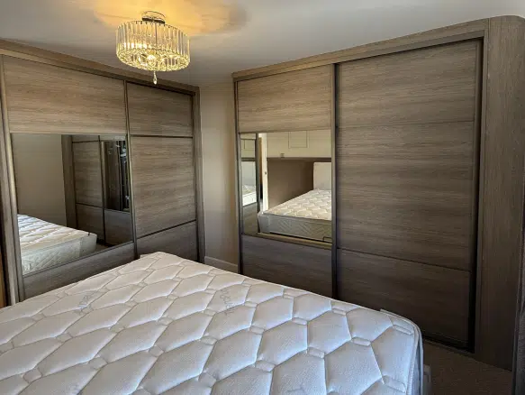 Sliding wardrobes with horizontal grained panels and mirror in brushed champagne frames