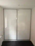 White glass silding wardrobe with matt silver frame, fitted in Yarm