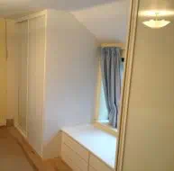 White glass in white frames fitted into the eaves of a room