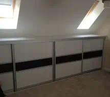 Small lidded wardrobe to fit into the eaves of the room, in fineline white and black