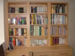Bookcase fitted ontop of a corner desk