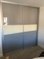 Stone grey glass divided in half by a pearl white strip, fitted in Stockton