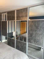 Anthracite metal rock wooden panel split with quarter half quarter splits with mirror where the outer doors are a negtive version of the middle doors, fitted in Marske